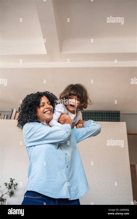 Mother Carrying Her Little Daughter Over Her Shoulder Stock Photo Alamy