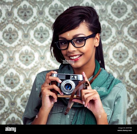 Capturing Every Moment A Young Woman Posing With A Camera Over A