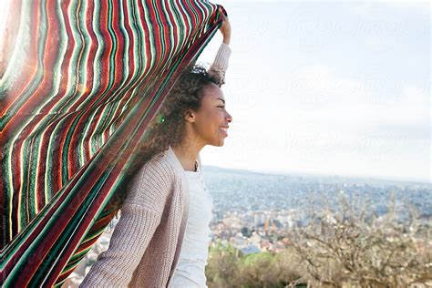 African American Woman Holding A Blanket On A Windy Day Above City