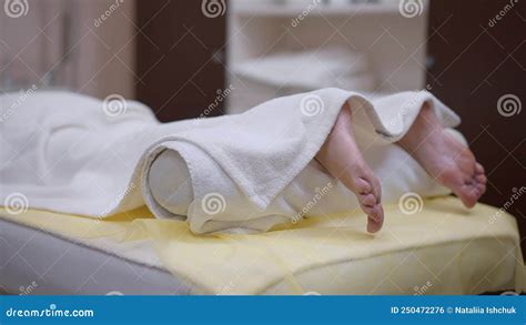 Carefree Relaxed Caucasian Woman Lying In Beauty Spa With Legs Covered