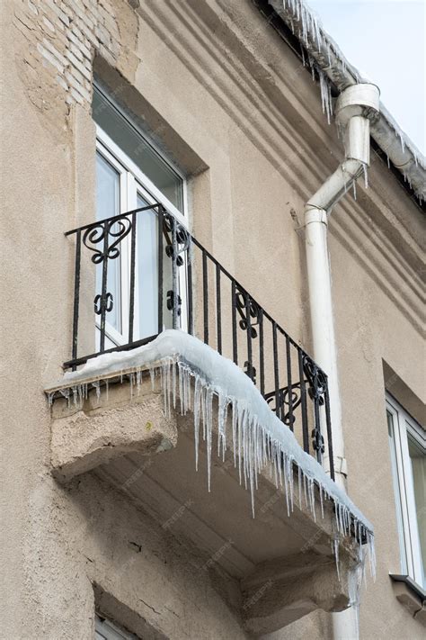 Premium Photo Large Icicles Hang From The Roof Of The Building And