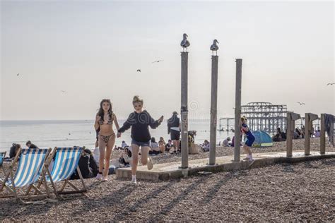 Dos Bonitas Jovencitas Una En Bikini Cogiendo La Mano En La Playa De Brighton Con El Descarado