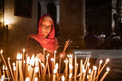 Mature Woman Lighting Candle In Christian Church In Middle East High