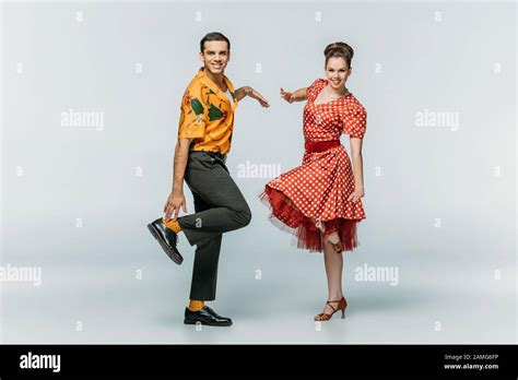 Stylish Dancers Looking At Camera While Dancing Boogie Woogie On Grey