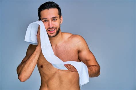 Un Tipo Sonriente De Pelo Negro Con Barba Se Limpia La Cara Con Una