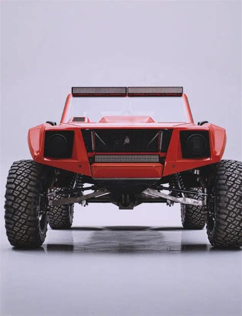 A Red Four Wheeled Vehicle With Large Tires And Lights On It S Front End