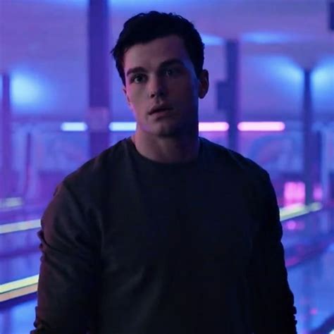 a young man standing in front of a bowling alley