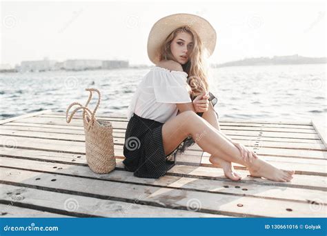 Portrait Of A Cute Girl Outdoors In Sitting On A Pier In The Spring