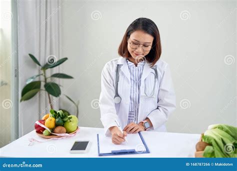 Portrait Of Young Smiling Female Nutritionist In The Consultation Room