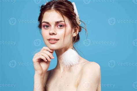 Woman With Fluffy Earrings Nude Shoulders Glamor Blue Background