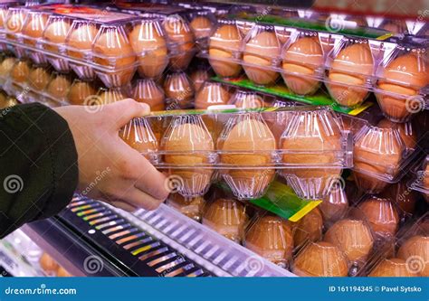 Buying Eggs In A Supermarket Buyer Holds In His Hand A Package Of Raw