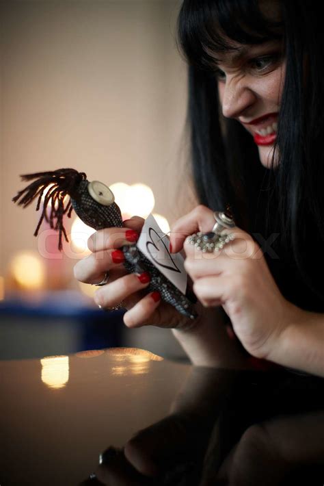 A female witch with a voodoo doll doing black magic | Stock image ...