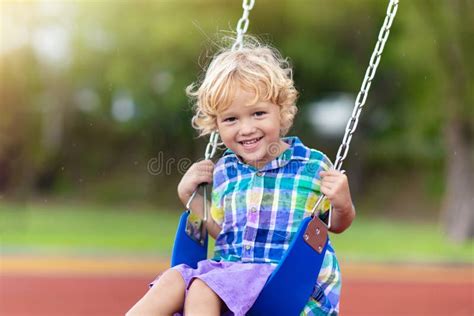 Niño En Zona De Juegos Niños Jugando Al Aire Libre Foto De Archivo