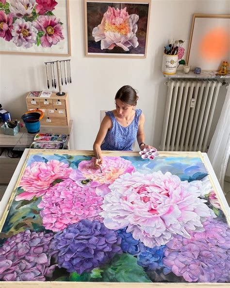 A Woman Is Painting Flowers On A Large Piece Of Paper With Watercolors