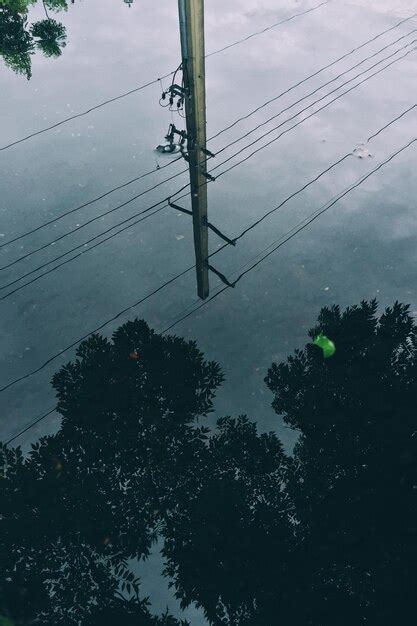 Premium Photo Reflection Of Electricity Pylon In Puddle On Street