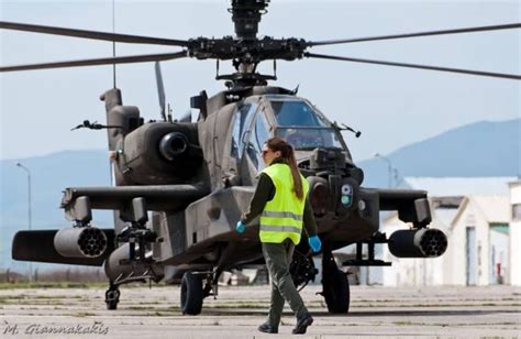 a man in yellow vest walking next to a helicopter