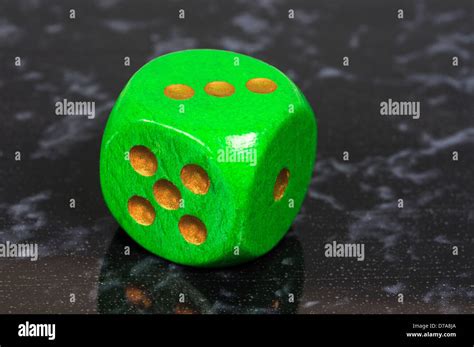 Platonic Regular 6 Sided Green Die With Gold Pips Against A Black And