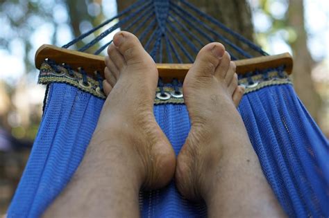 Pies De Hombre Acostados En La Cama De Vacaciones Foto Premium