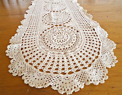 A White Crocheted Doily Sitting On Top Of A Wooden Table