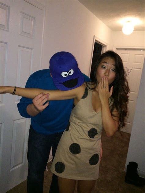 a man and woman dressed up as cookie monster and lady bug, standing in front of a door