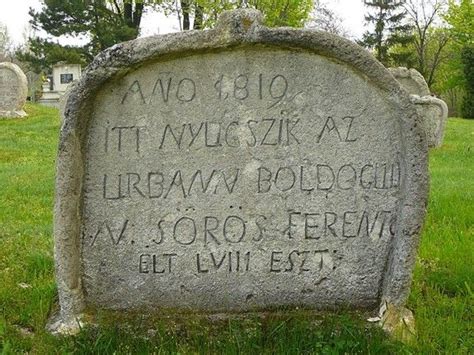 An Old Grave With Writing On It In The Grass