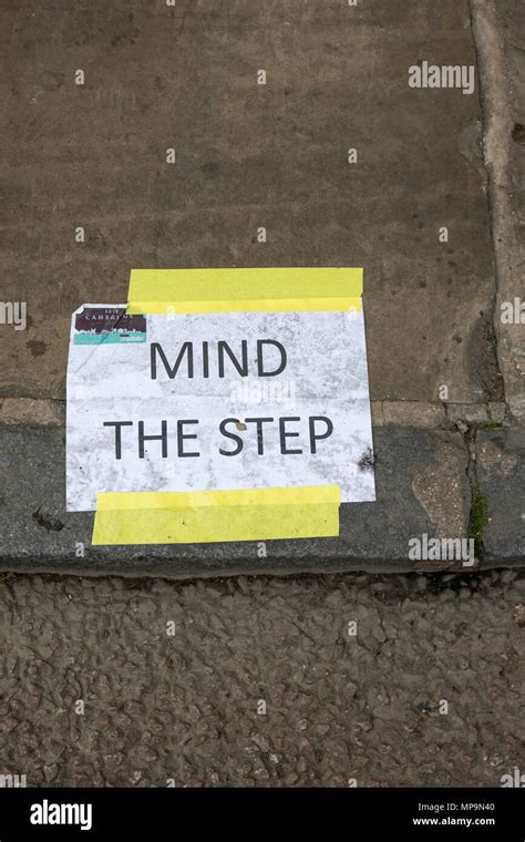 Mind the step warning sign in Cambridge city centre, UK Stock Photo - Alamy