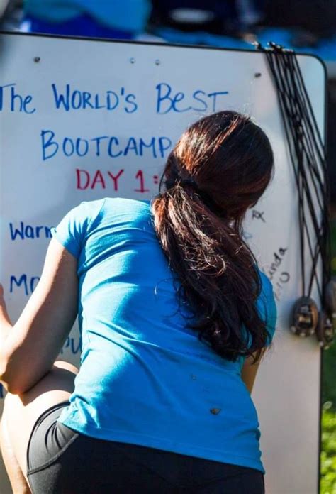 A Woman Squatting Down In Front Of A Sign