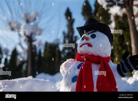 A Snowman With A Creepy Grimace In A Hat And Scarf Stock Photo Alamy