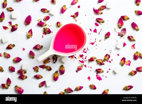 Rose tea in cups with flowers on white background Stock Photo - Alamy