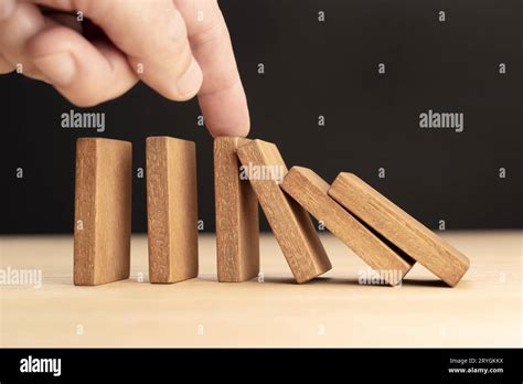 Hand Stopping Falling Wooden Dominoes Effect Stock Photo Alamy