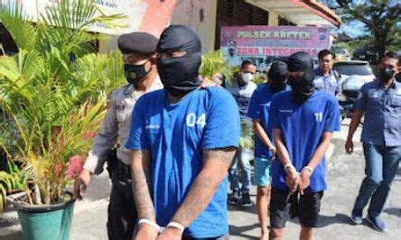 A Group Of People In Blue Shirts And Black Masks Are Standing Near A