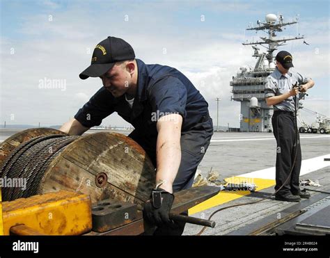 Los Dos Mates De Boatswain Trabajan Juntos Para Colocar Un Cable De Retracción En Una De Las