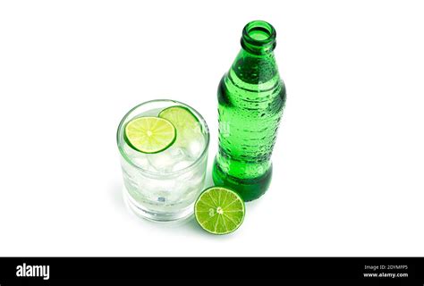 Green Bottle And Transparent Glass With Lime Lemonade On White