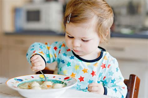 Adorable Baby Girl Eating From Spoon Vegetable Noodle Soup Food Child