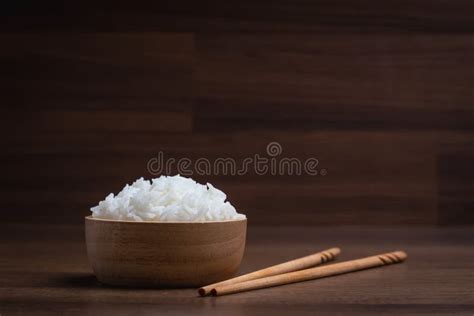 Cooked White Rice In A Wooden Dish With Green Onion Sliced On Top With