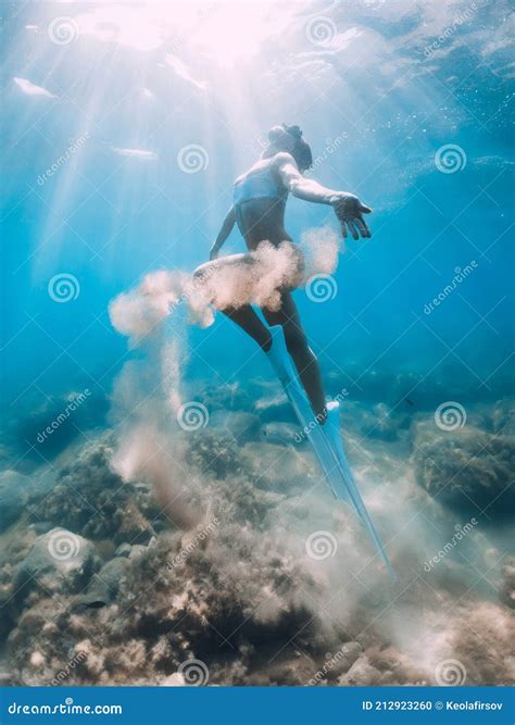 Woman Glides With Sand In Hand Free Diver With Fins Posing Underwater