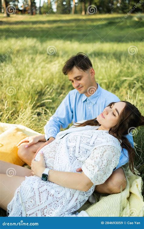 Happy And Young Pregnant Couple Hugging In Nature Stock Image Image