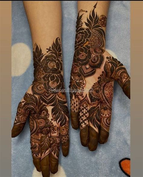 Two Hands With Henna Tattoos On Them One Is Brown And The Other Is Black