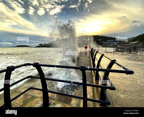 Wave hitting the promenade at East Looe Beach, Cornwall Stock Photo - Alamy