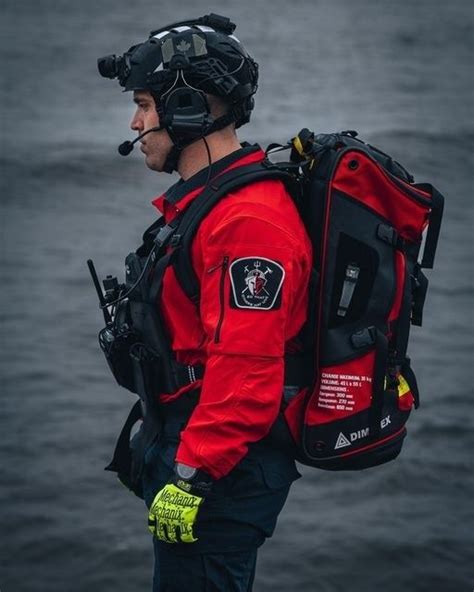 A Man Wearing A Life Jacket And Goggles Standing In Front Of The Water