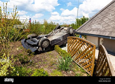 Car Lying On The Roof In A Garden After A Traffic Accident Stock Photo