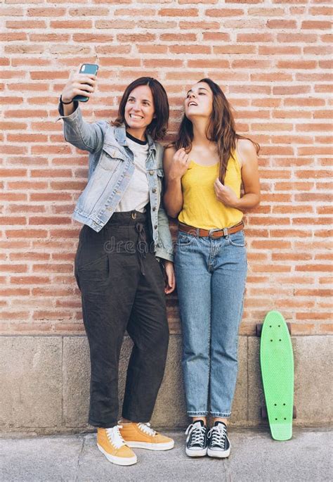 Pares De Las Mujeres Jovenes Que Hacen Un Selfie Detr S De La Pared De