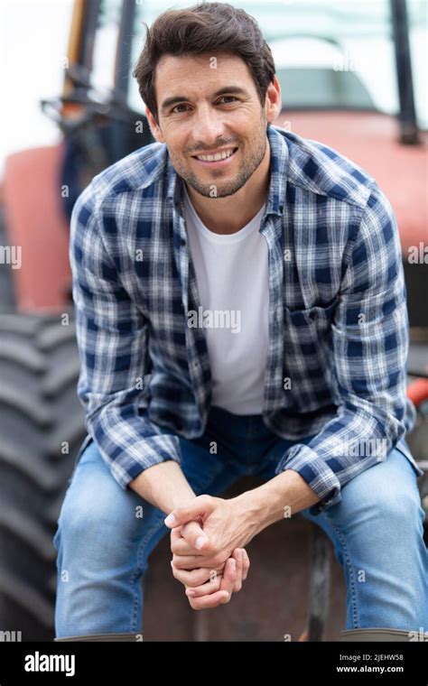 Male Farmer Sat On Tractor Wheel Stock Photo Alamy