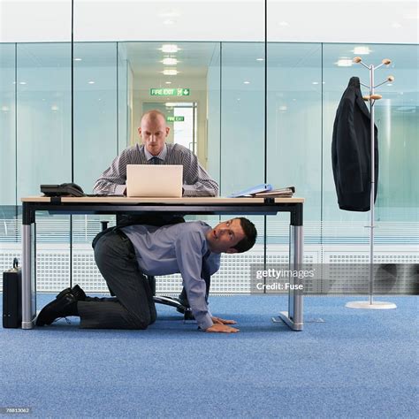 Businessman Hiding Under Office Desk High Res Stock Photo Getty Images