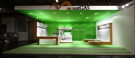 A Green And White Booth At A Trade Show With Lights On The Ceiling