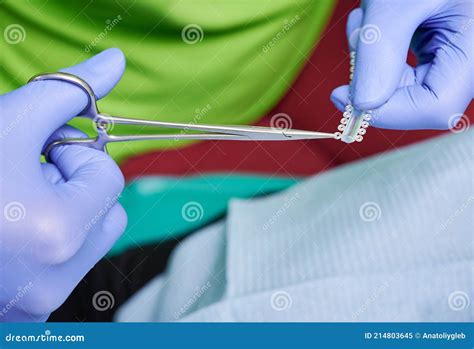 orthodontist hands cutting elastic ligature ties  dental scissors