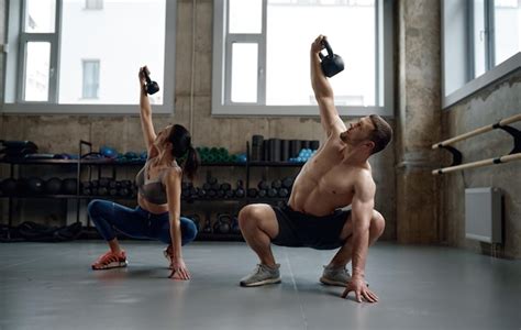 Mann und frau mit gutem körperbau halten schwere kettlebell für swing