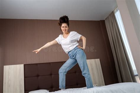 Positive Expressions Happy Young Woman Dancing On The Bed In The