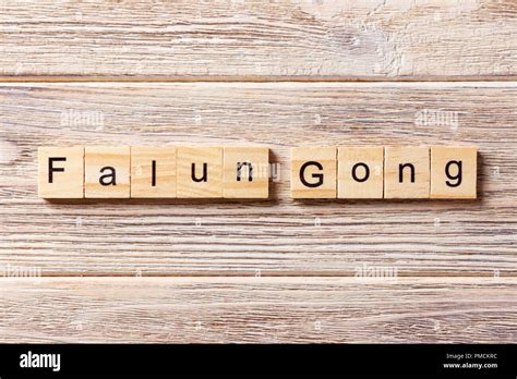 Falun Gong word written on wood block. Falun Gong text on table ...