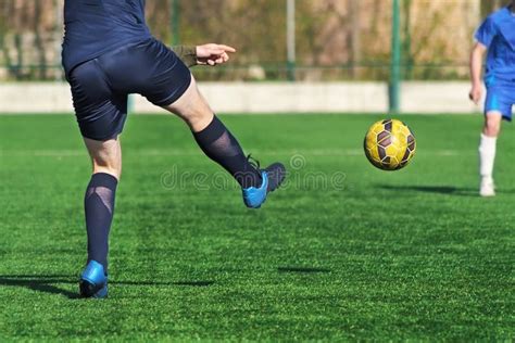 Atleta Que Golpea El Balón De Fútbol Con El Pie En Estadio Imagen de